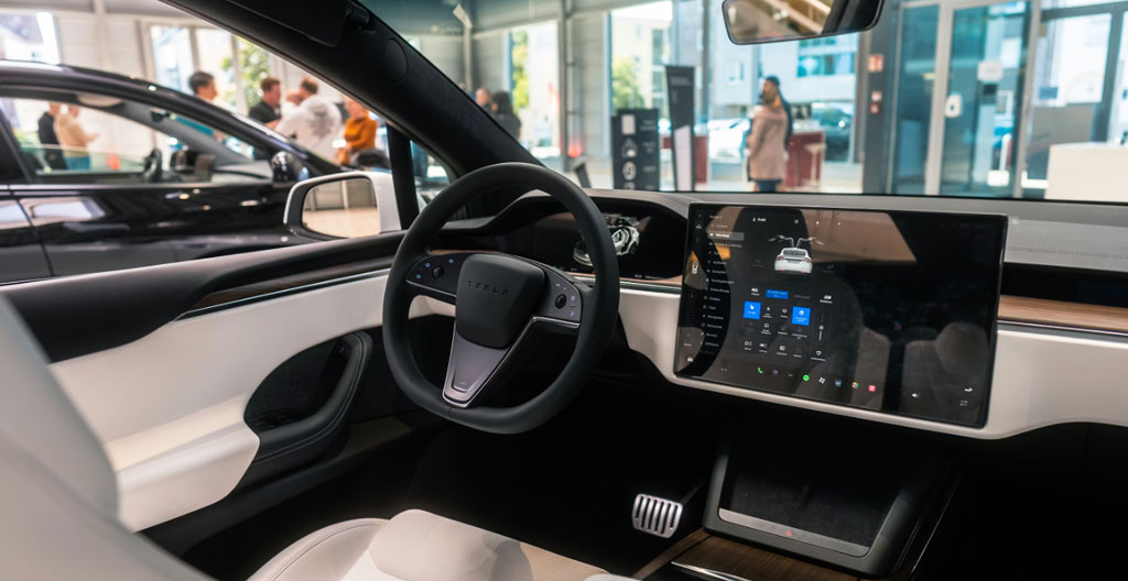 Intérieur d'une voiture moderne vue depuis la place passager, volant et tableau de bord légèrement floutés, lumière naturelle du jour
