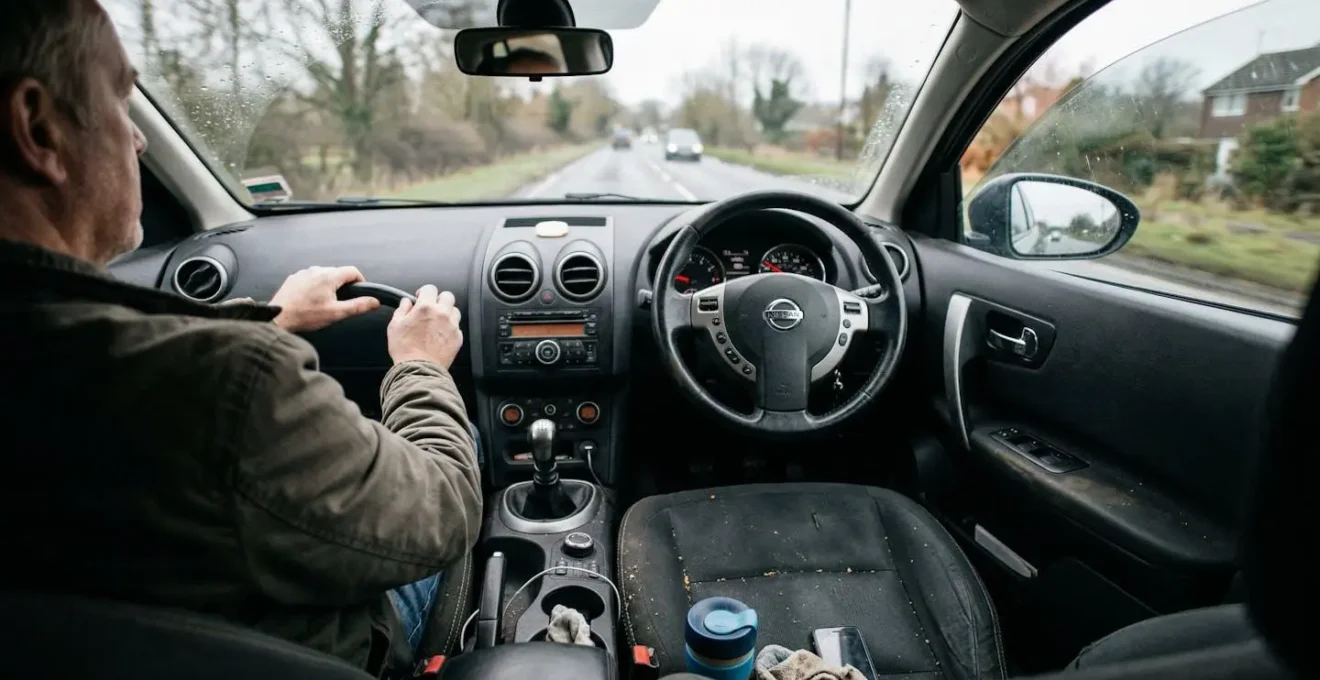 Intérieur d'une voiture moderne vue depuis la place passager, volant et tableau de bord légèrement floutés, lumière naturelle du jour
