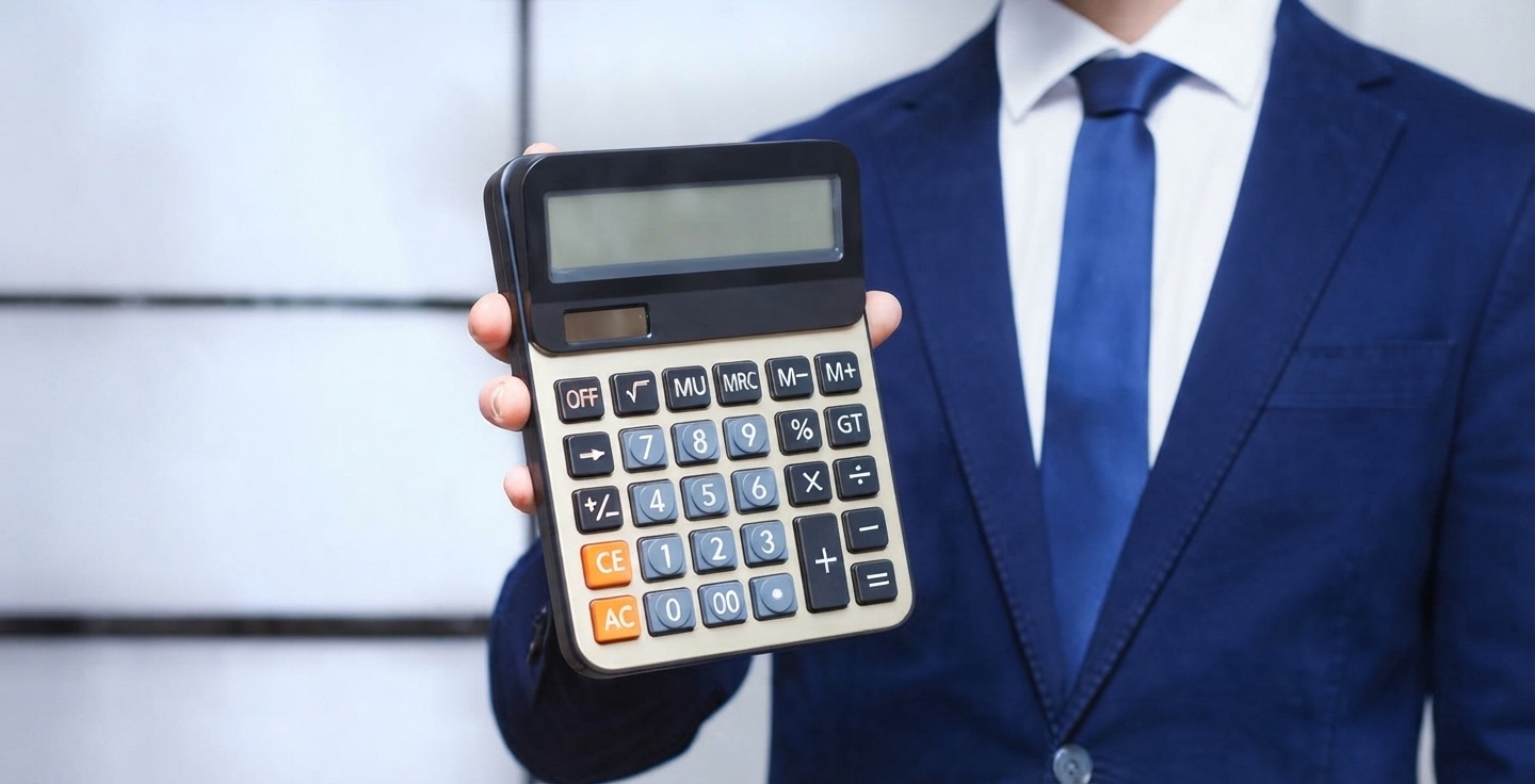 Personne comparant des simulations de prêt immobilier en ligne sur ordinateur portable tout en prenant des notes manuscrites